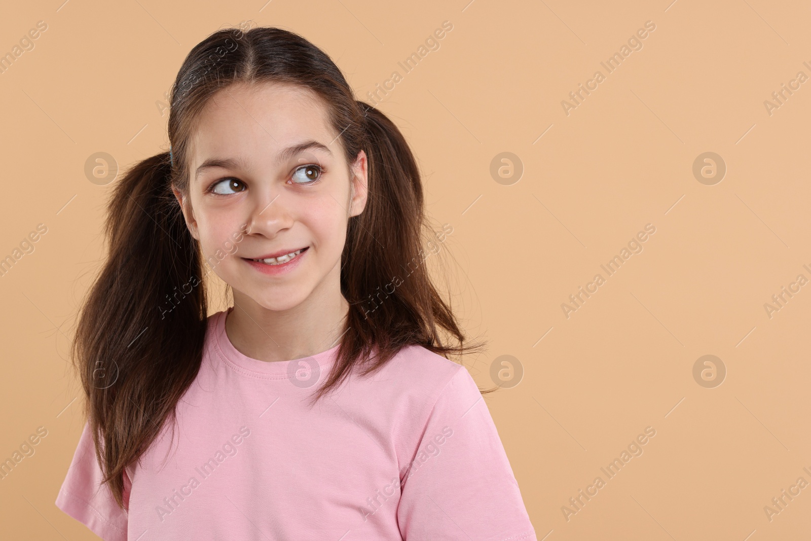 Photo of Portrait of beautiful girl on beige background, space for text