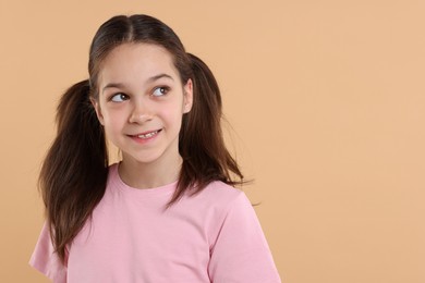 Photo of Portrait of beautiful girl on beige background, space for text