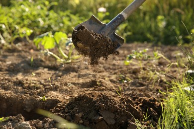 Digging soil with shovel on sunny day, closeup