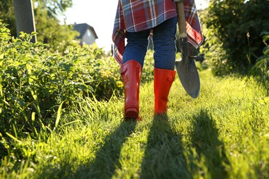 Farmer walking with shovel on sunny day, closeup