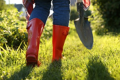 Photo of Farmer walking with shovel on sunny day, closeup