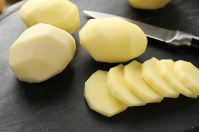 Fresh raw potatoes and knife on table