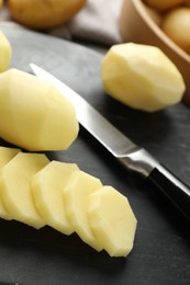 Fresh raw potatoes and knife on table