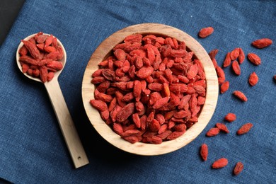 Photo of Dried goji berries on blue cloth, top view