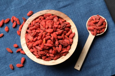 Photo of Dried goji berries on blue cloth, top view