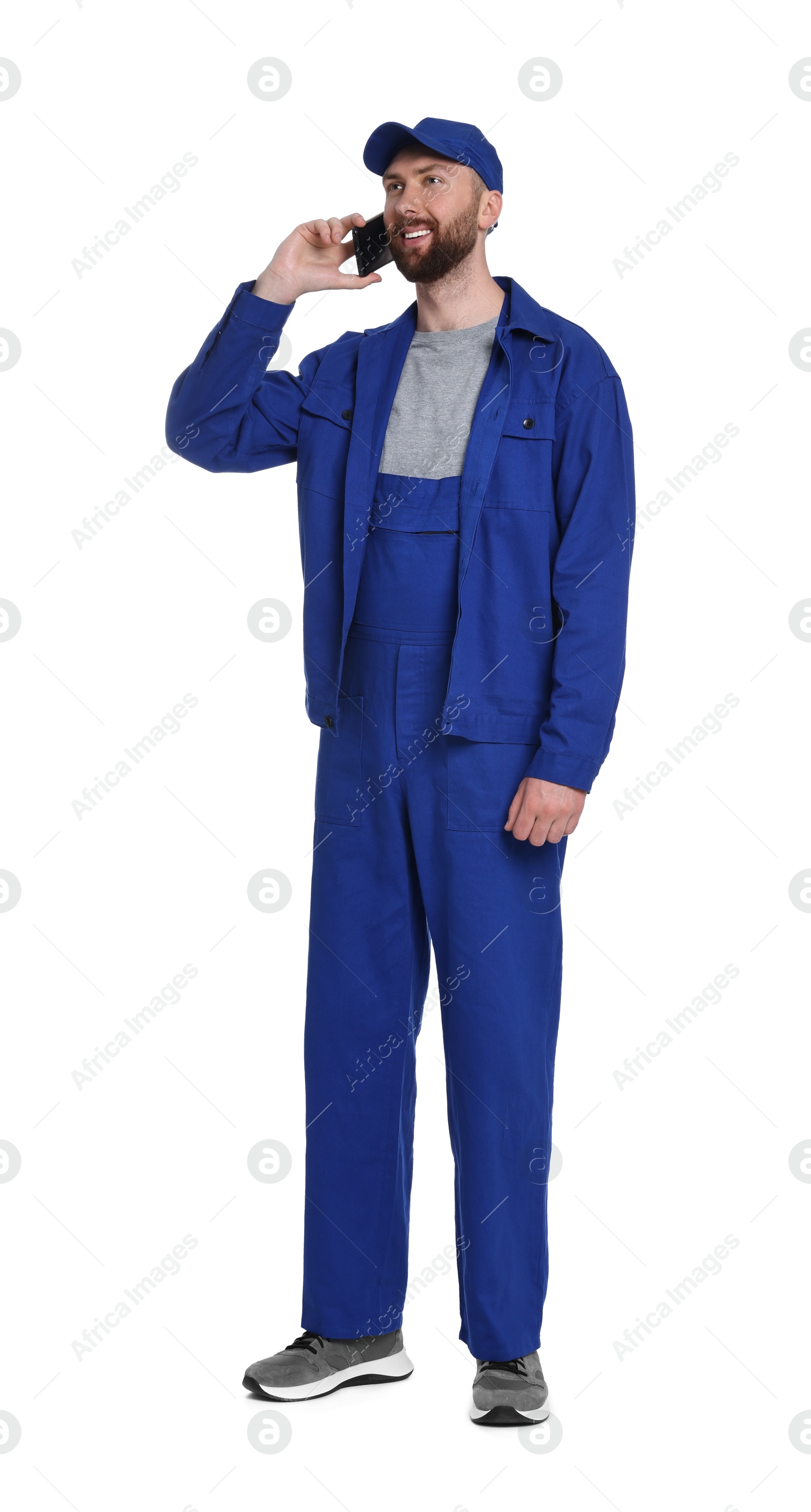 Photo of Professional auto mechanic talking on phone against white background