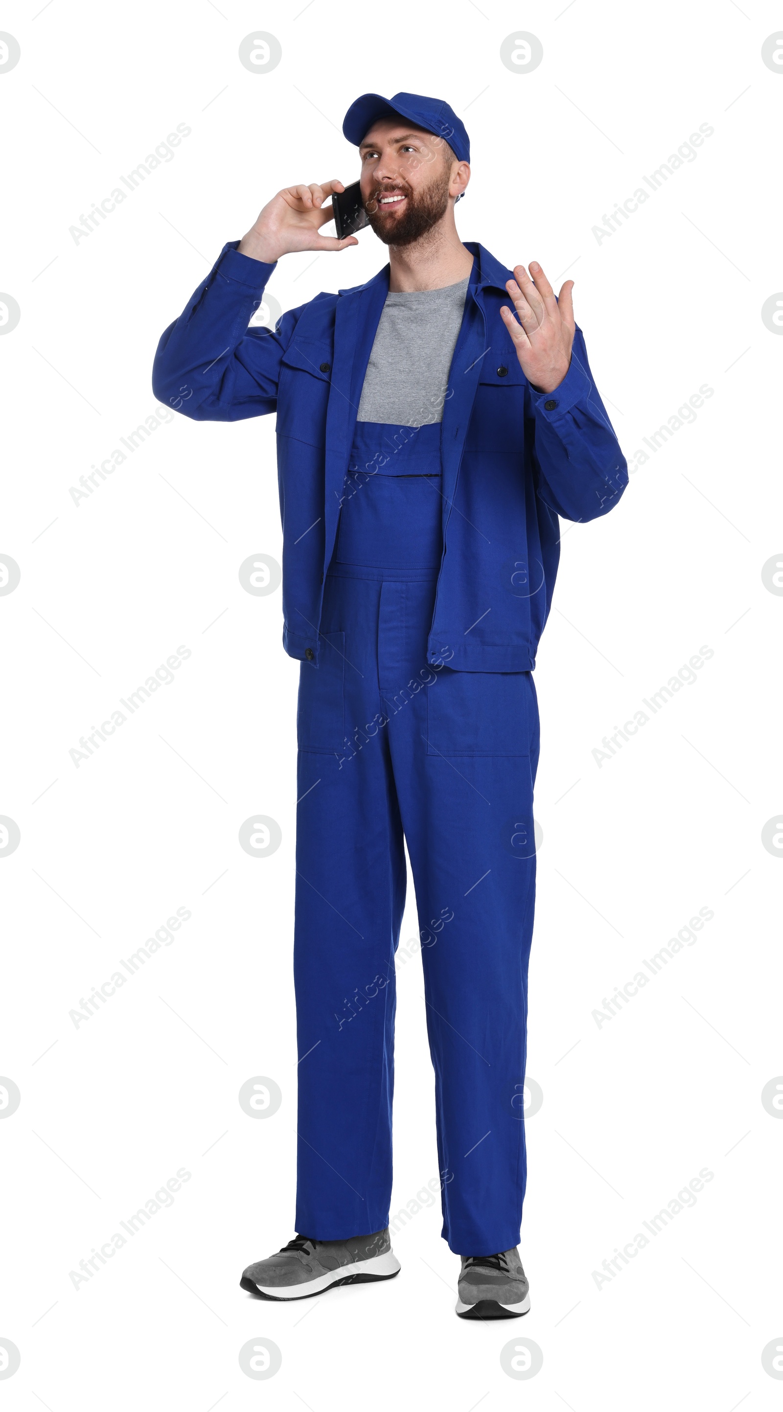 Photo of Professional auto mechanic talking on phone against white background