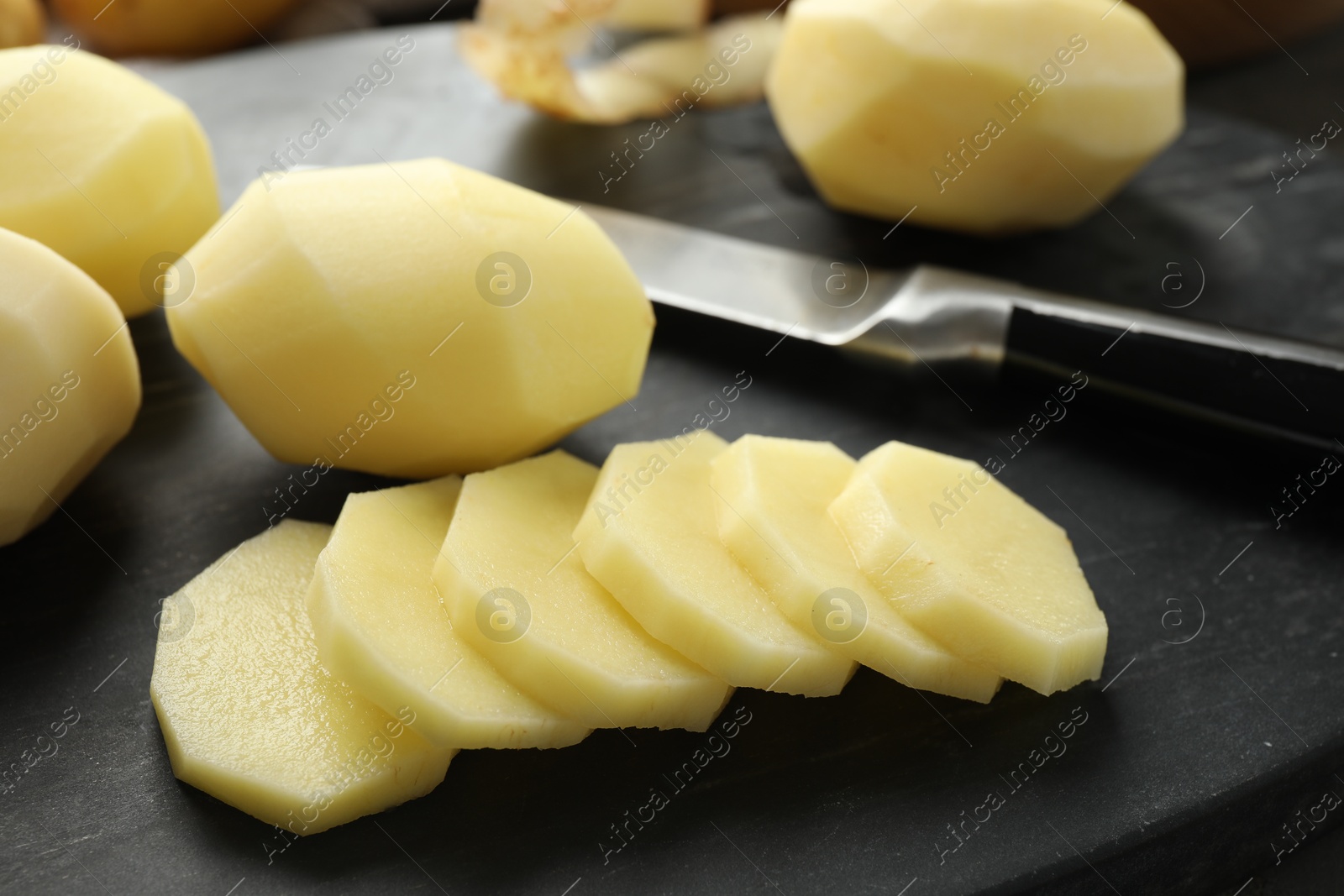 Photo of Fresh raw potatoes and knife on table