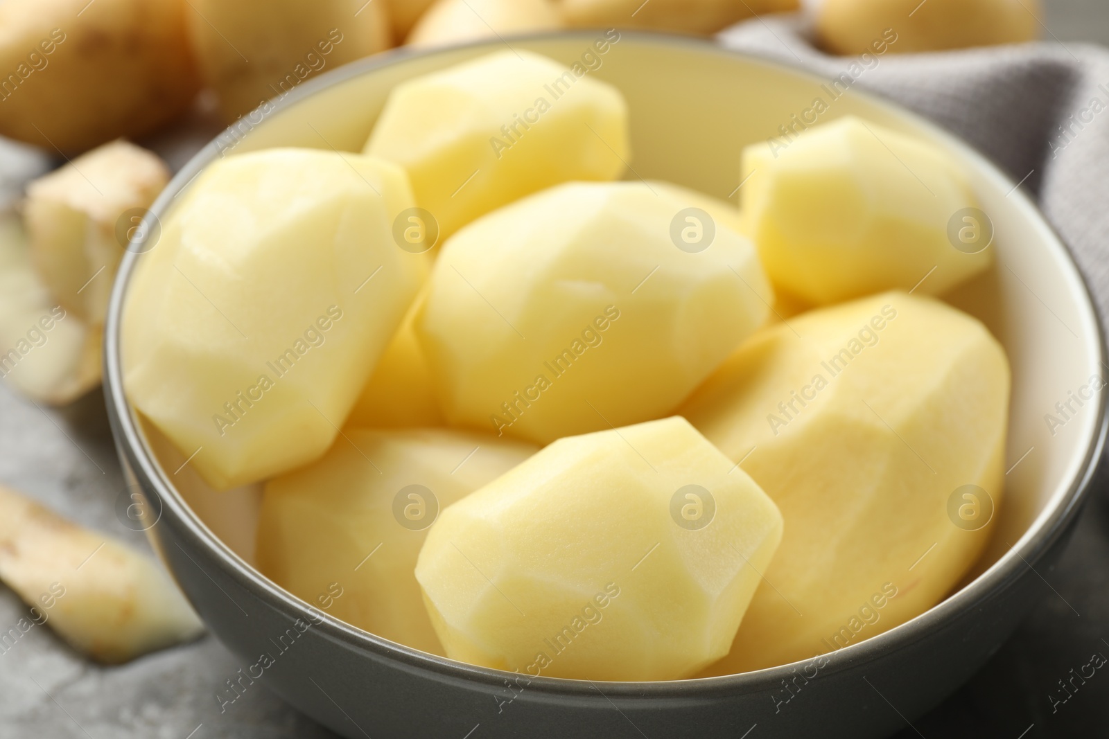 Photo of Fresh raw potatoes in bowl on table, closeup