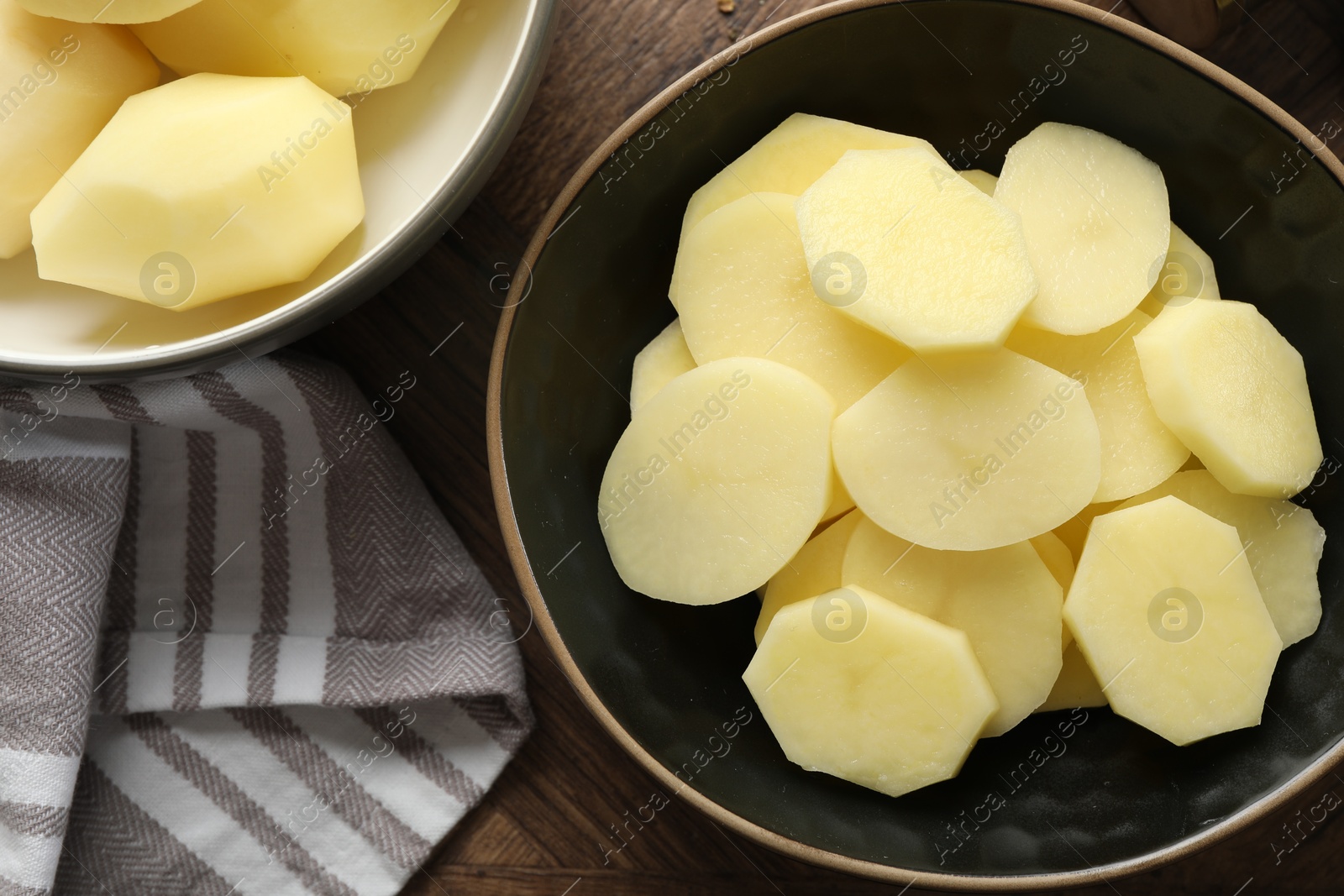 Photo of Fresh raw potatoes on wooden table, top view