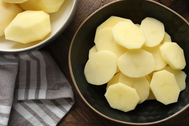 Photo of Fresh raw potatoes on wooden table, top view