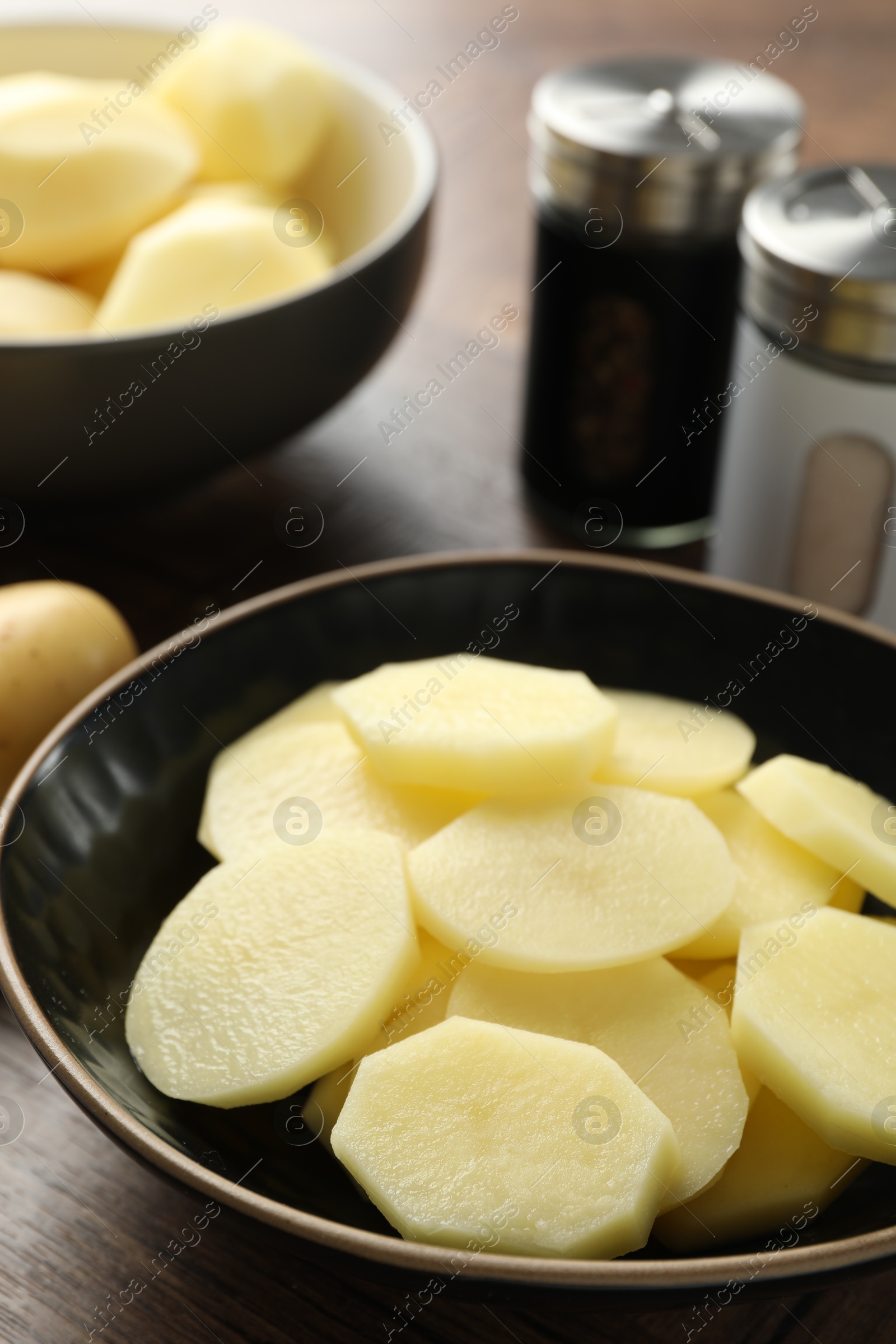 Photo of Fresh raw potatoes and spices on wooden table