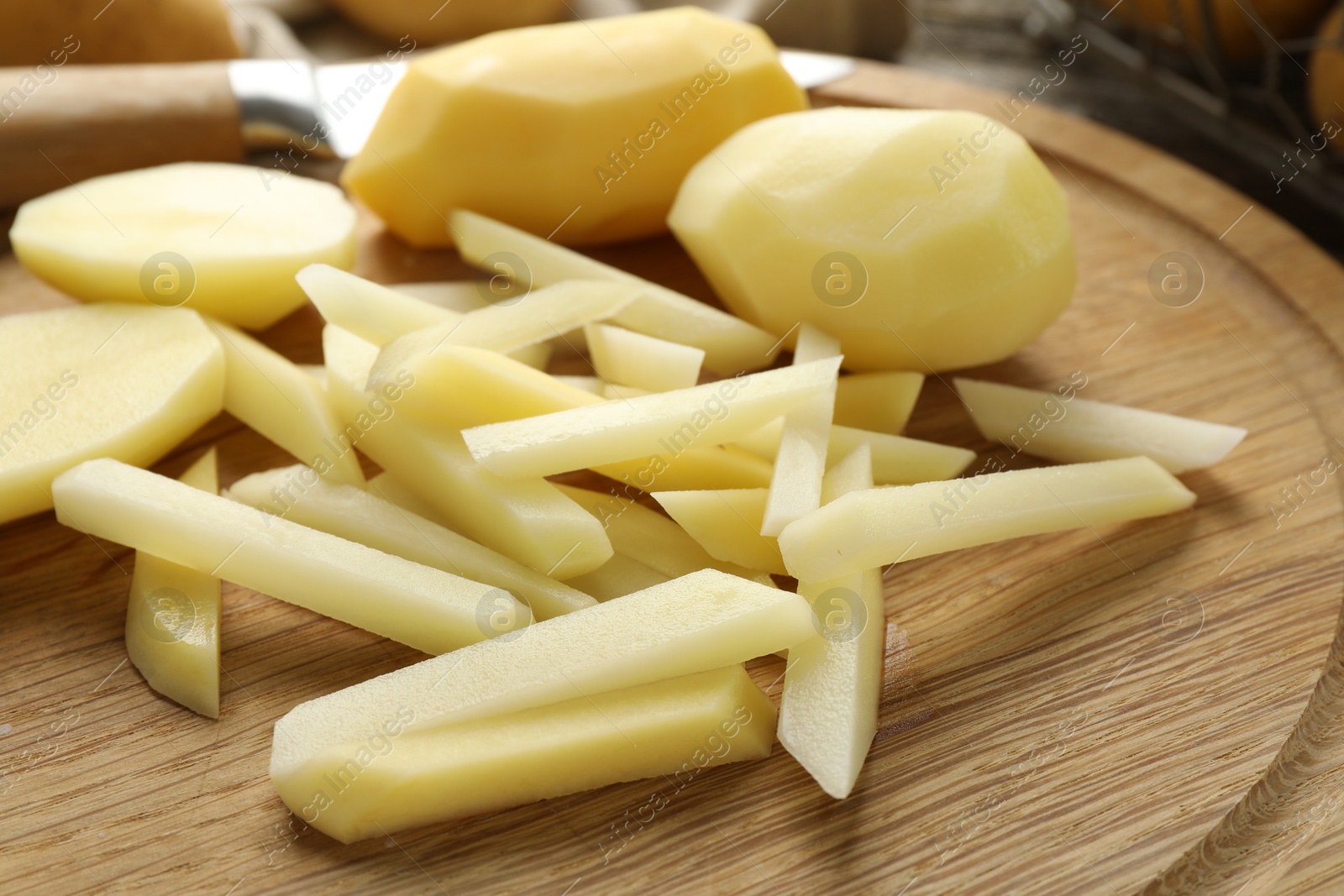 Photo of Whole and cut fresh raw potatoes on table