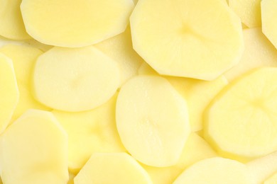 Photo of Cut fresh raw potatoes as background, top view