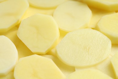 Photo of Cut fresh raw potatoes as background, closeup