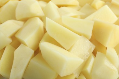 Photo of Peeled fresh raw potatoes as background, closeup