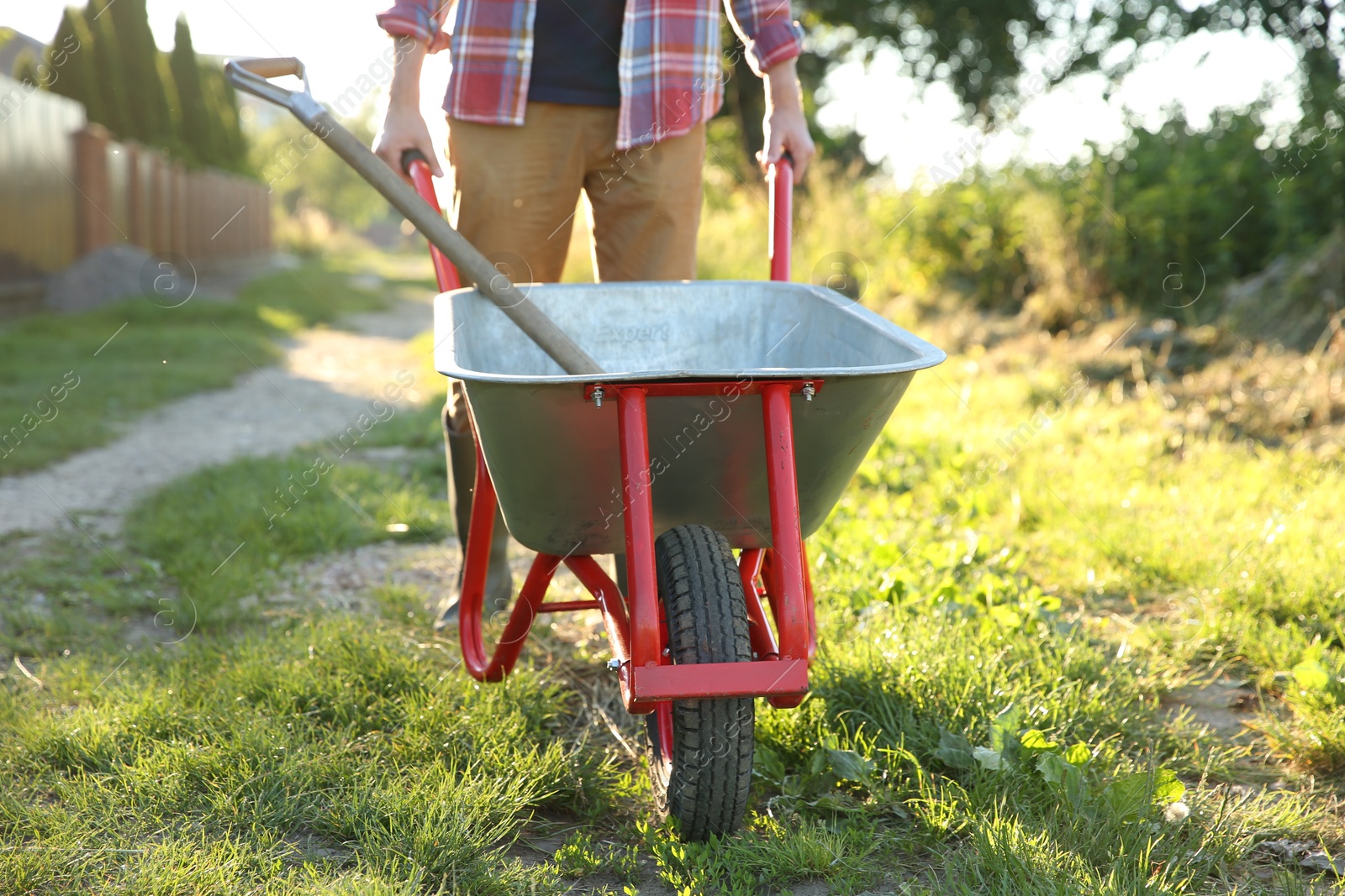 Photo of Farmer with wheelbarrow outdoors on sunny day, closeup