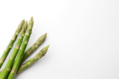 Fresh green asparagus stems on white background, top view. Space for text