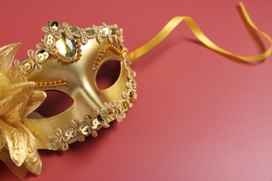 Beautiful carnival mask on red background, space for text