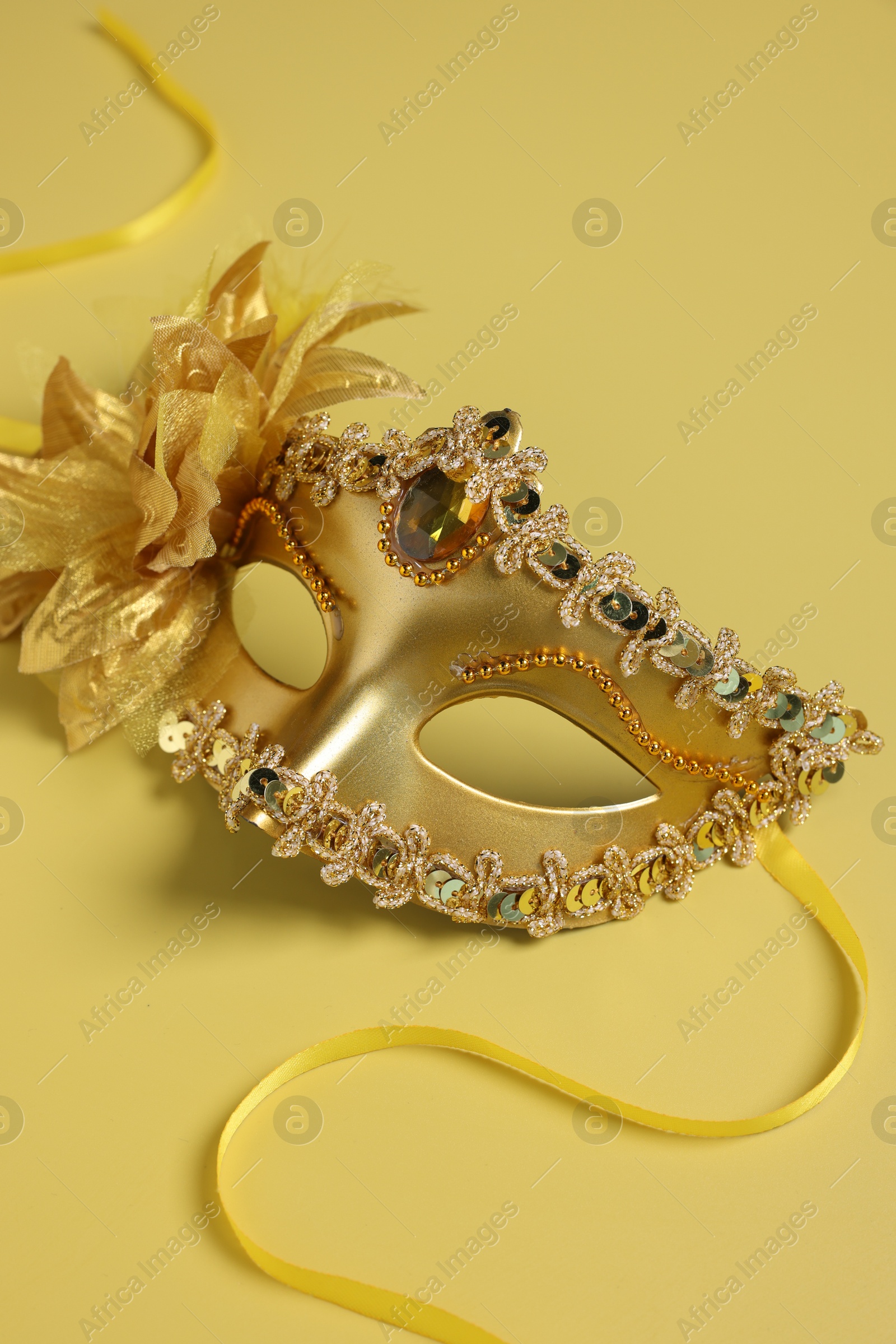 Photo of One beautiful carnival mask on yellow background