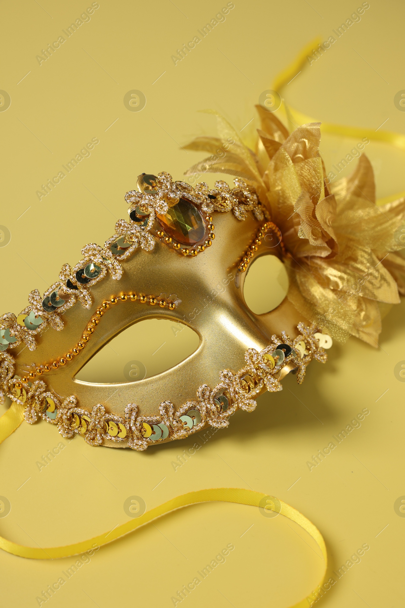 Photo of One beautiful carnival mask on yellow background