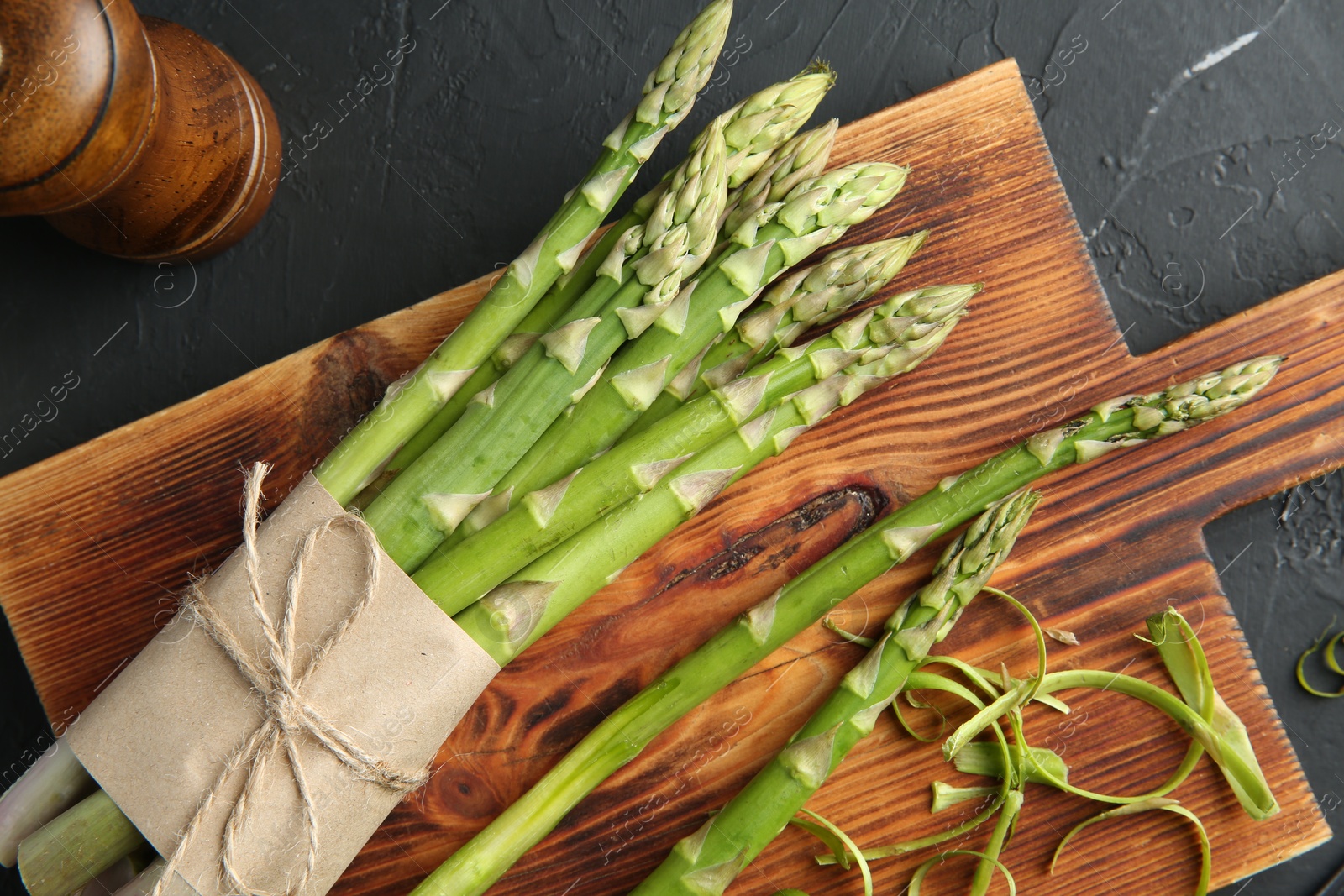 Photo of Fresh green asparagus stems and spices on gray textured table, flat lay