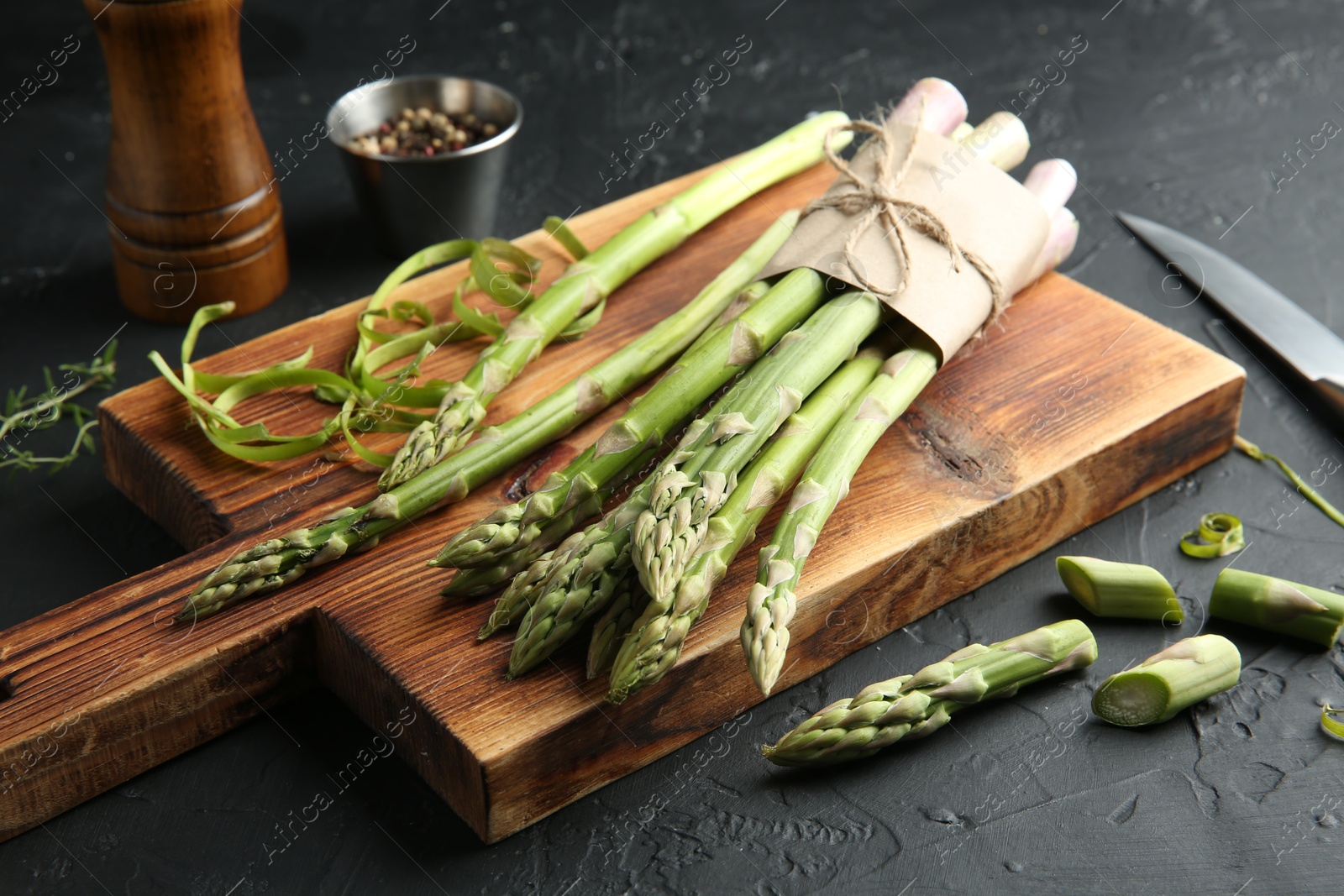 Photo of Fresh green asparagus stems on gray textured table, closeup