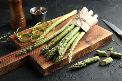 Fresh green asparagus stems on gray textured table, closeup