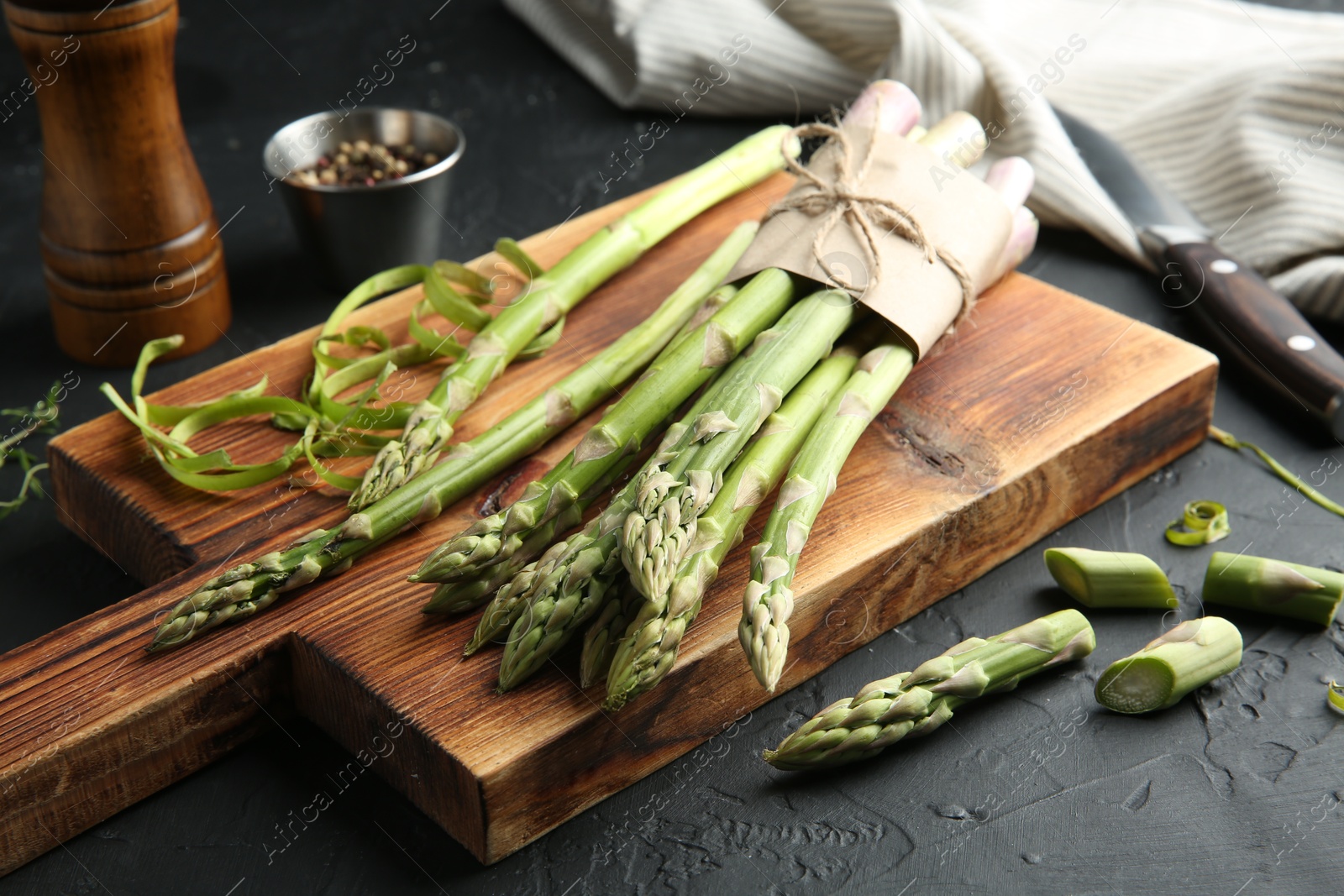 Photo of Fresh green asparagus stems on gray textured table, closeup