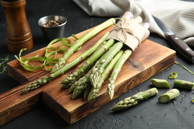 Fresh green asparagus stems on gray textured table, closeup