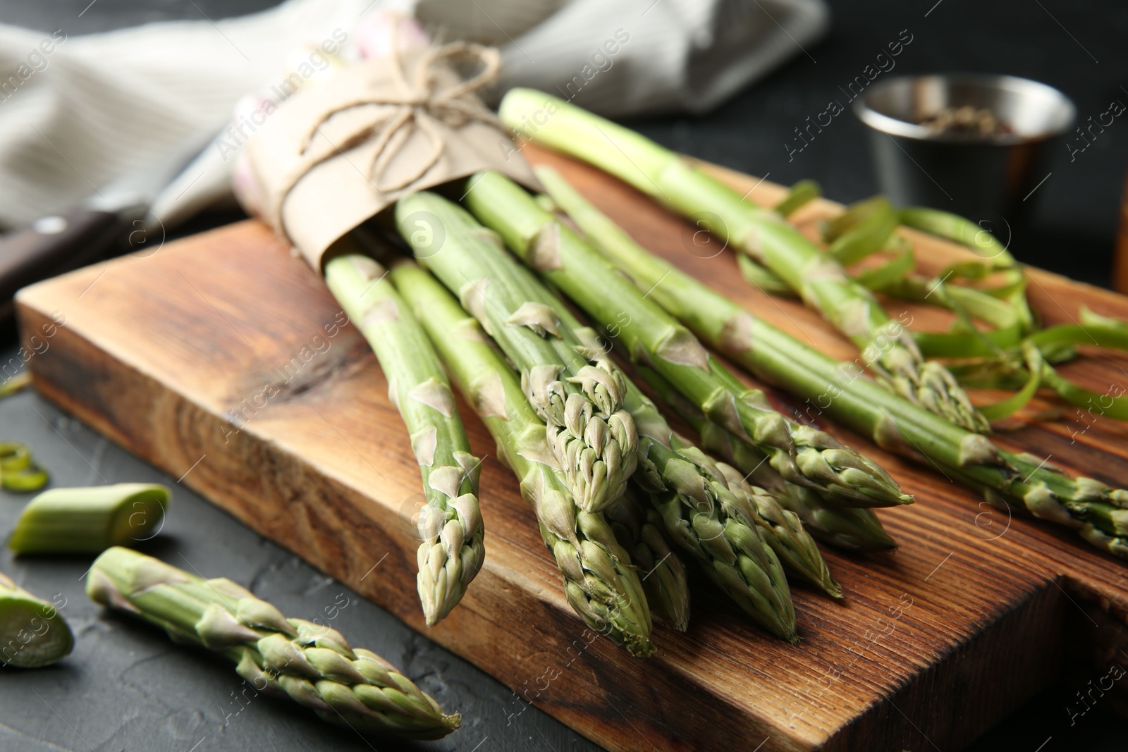 Photo of Fresh green asparagus stems on gray textured table, closeup