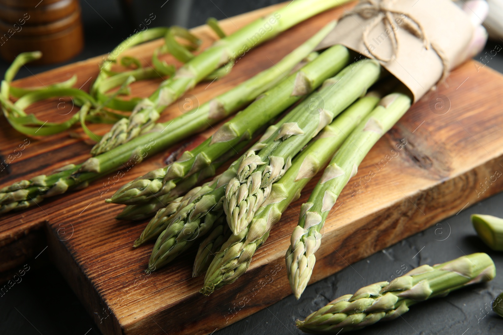 Photo of Fresh green asparagus stems on gray textured table, closeup