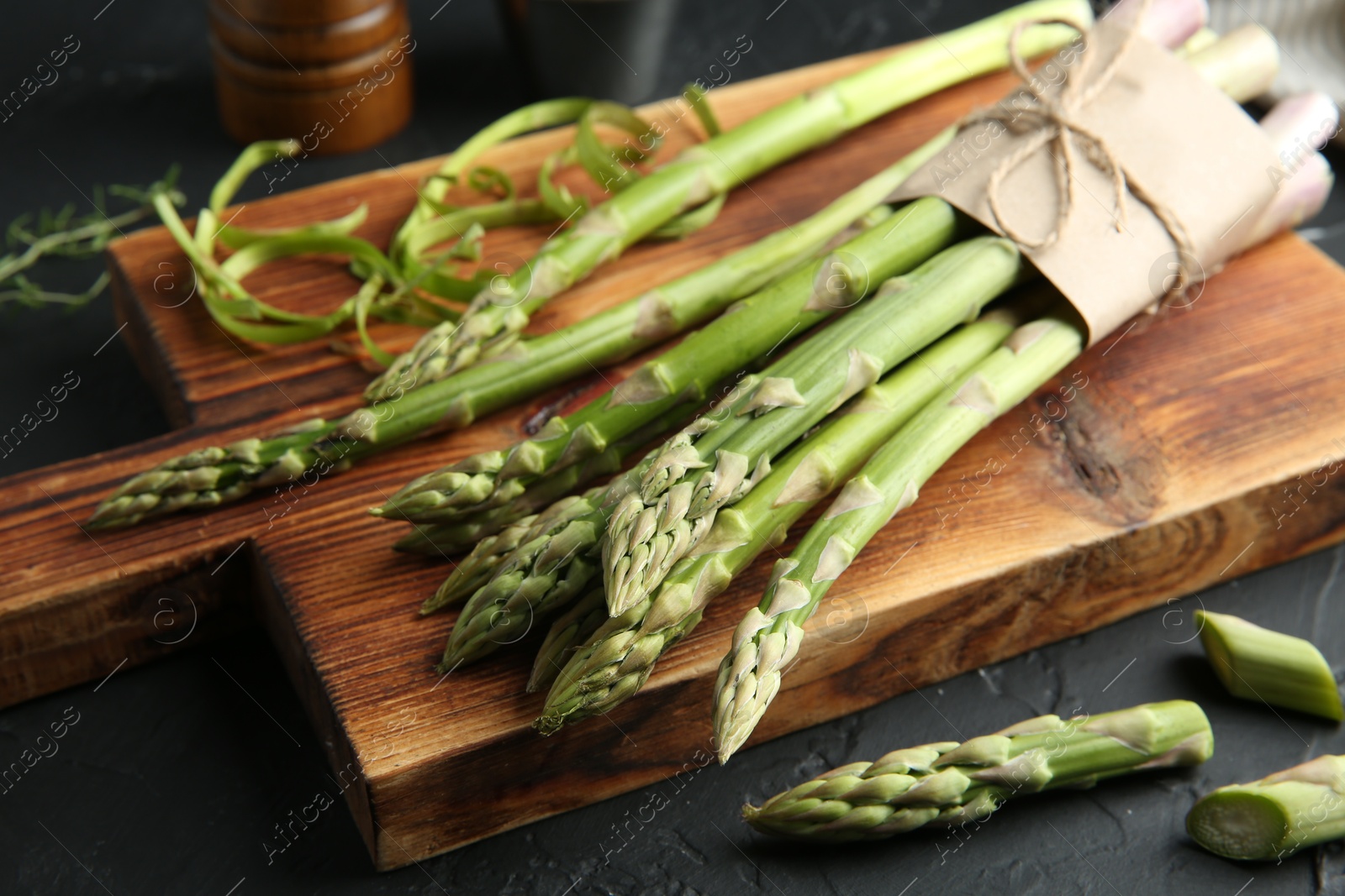 Photo of Fresh green asparagus stems on gray textured table, closeup