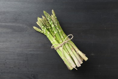 Bunch of fresh green asparagus stems on gray wooden table, top view