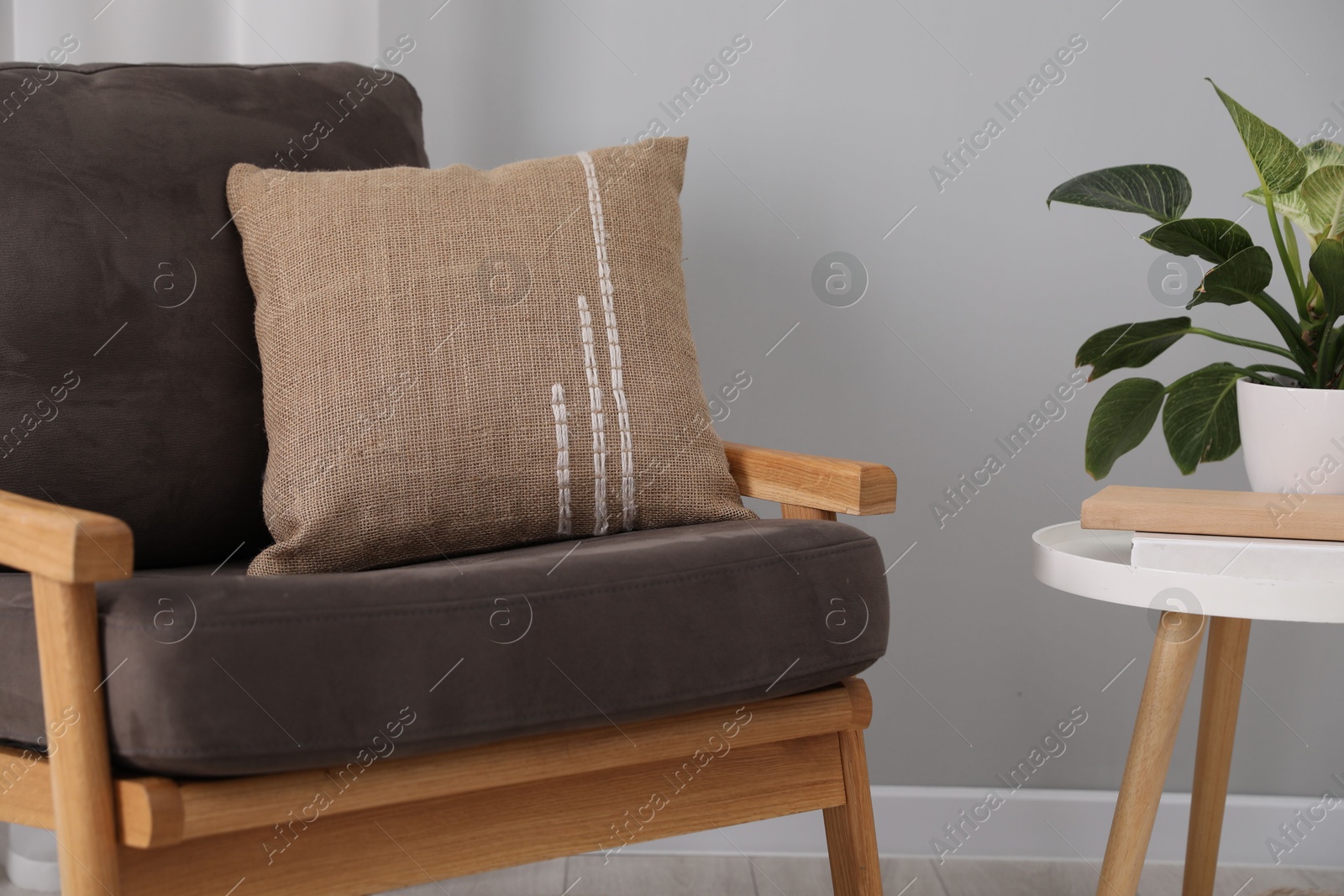 Photo of Soft pillow on armchair near coffee table indoors