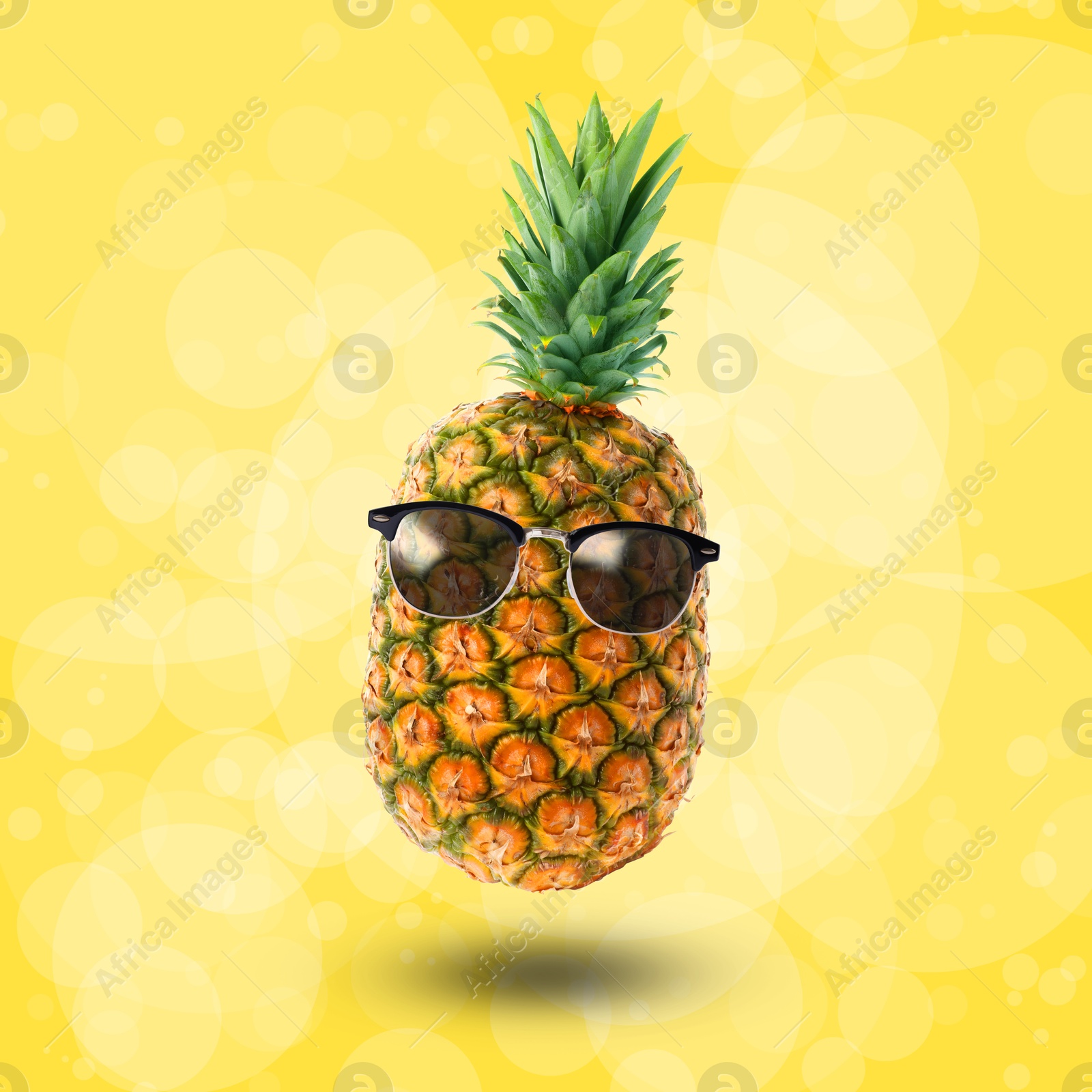 Image of Summer vibe. Pineapple with sunglasses on yellow background, bokeh effect. Party flyer or other seasonal