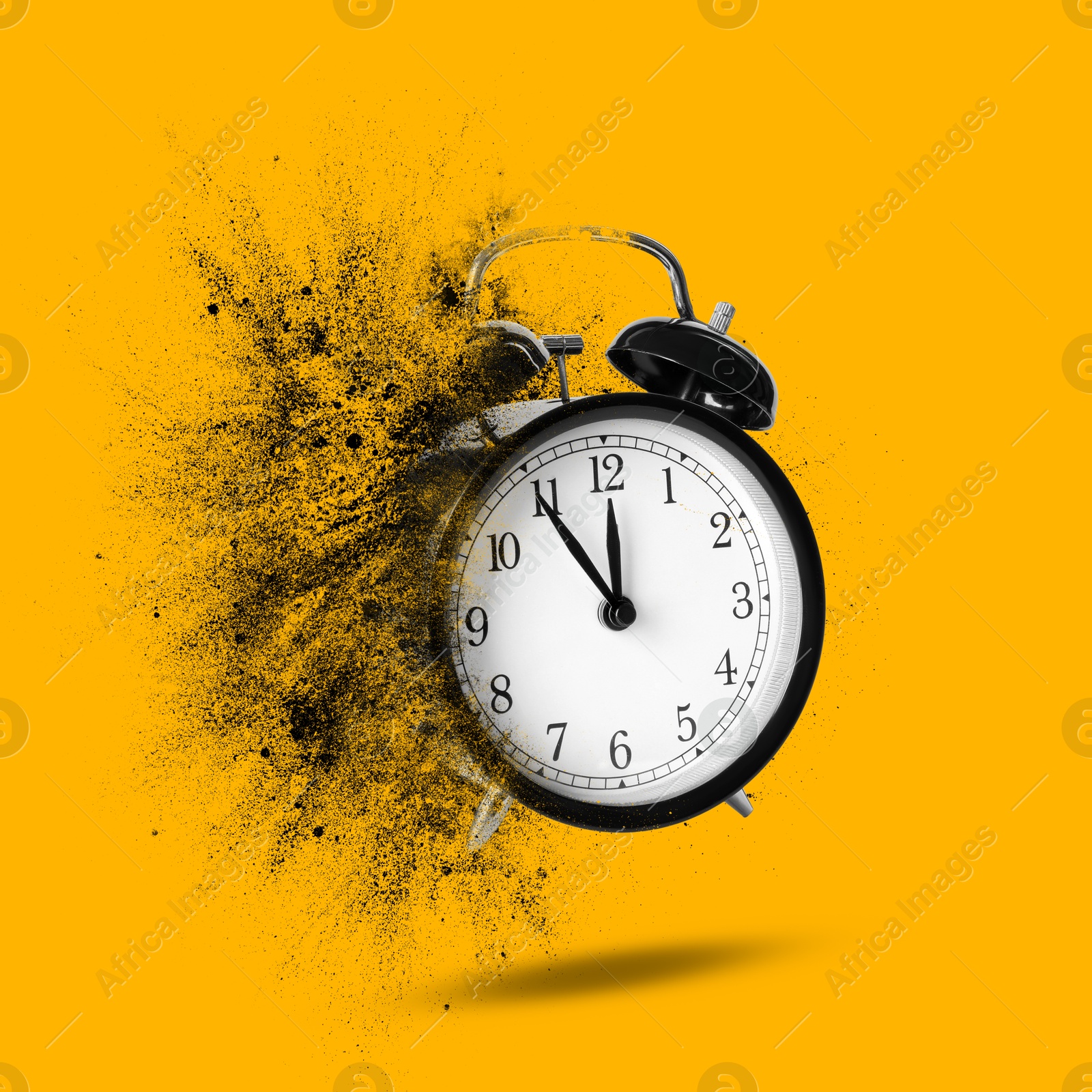 Image of Black alarm clock dissolving on orange background. Flow of time