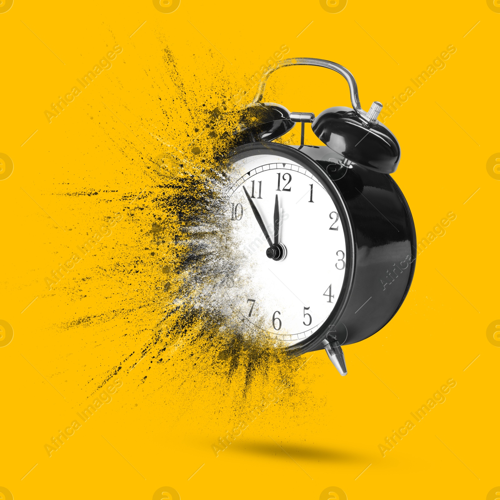 Image of Black alarm clock dissolving on orange background. Flow of time
