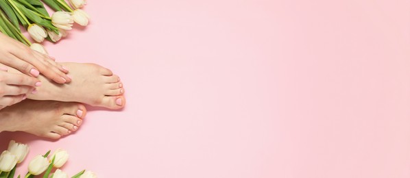 Woman showing neat toenails after pedicure procedure and flowers on pink background, top view. Banner design with space for text