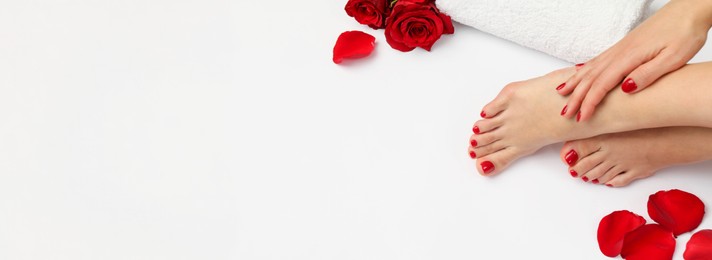 Image of Woman showing neat toenails and fingernails after pedicure and manicure procedures and flowers on white background, closeup. Banner design with space for text