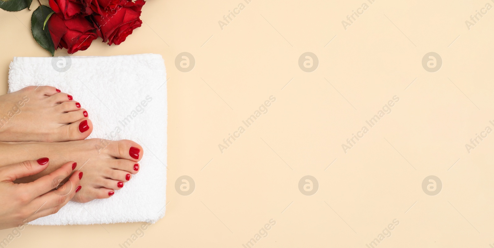 Image of Woman showing neat toenails and fingernails after pedicure and manicure procedures and flowers on beige background, top view. Banner design with space for text