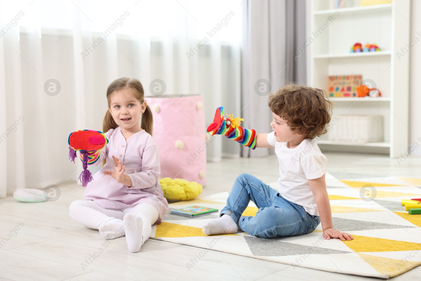 Photo of Cute little children playing with funny sock puppets in kindergarten