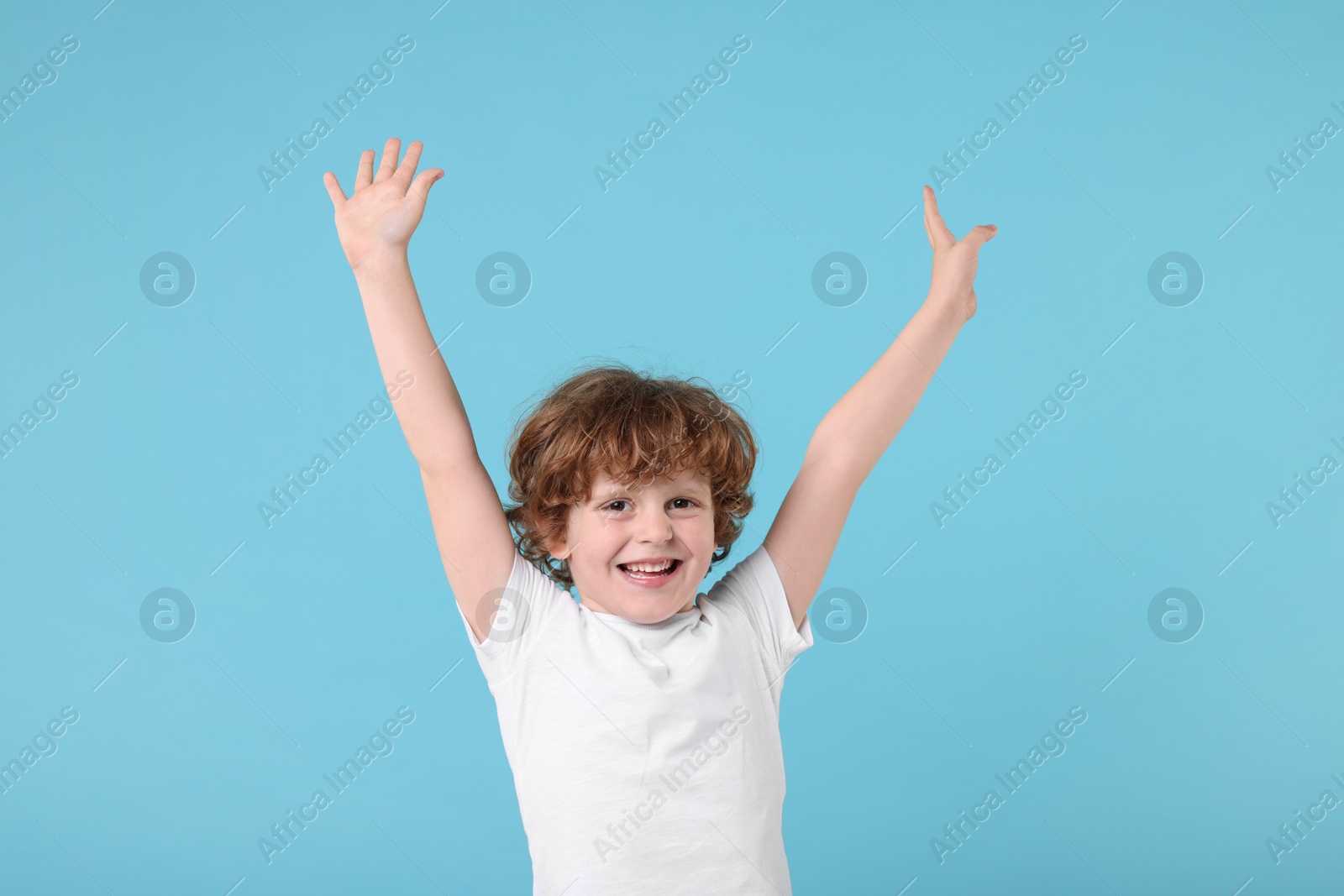 Photo of Portrait of cute little boy on light blue background