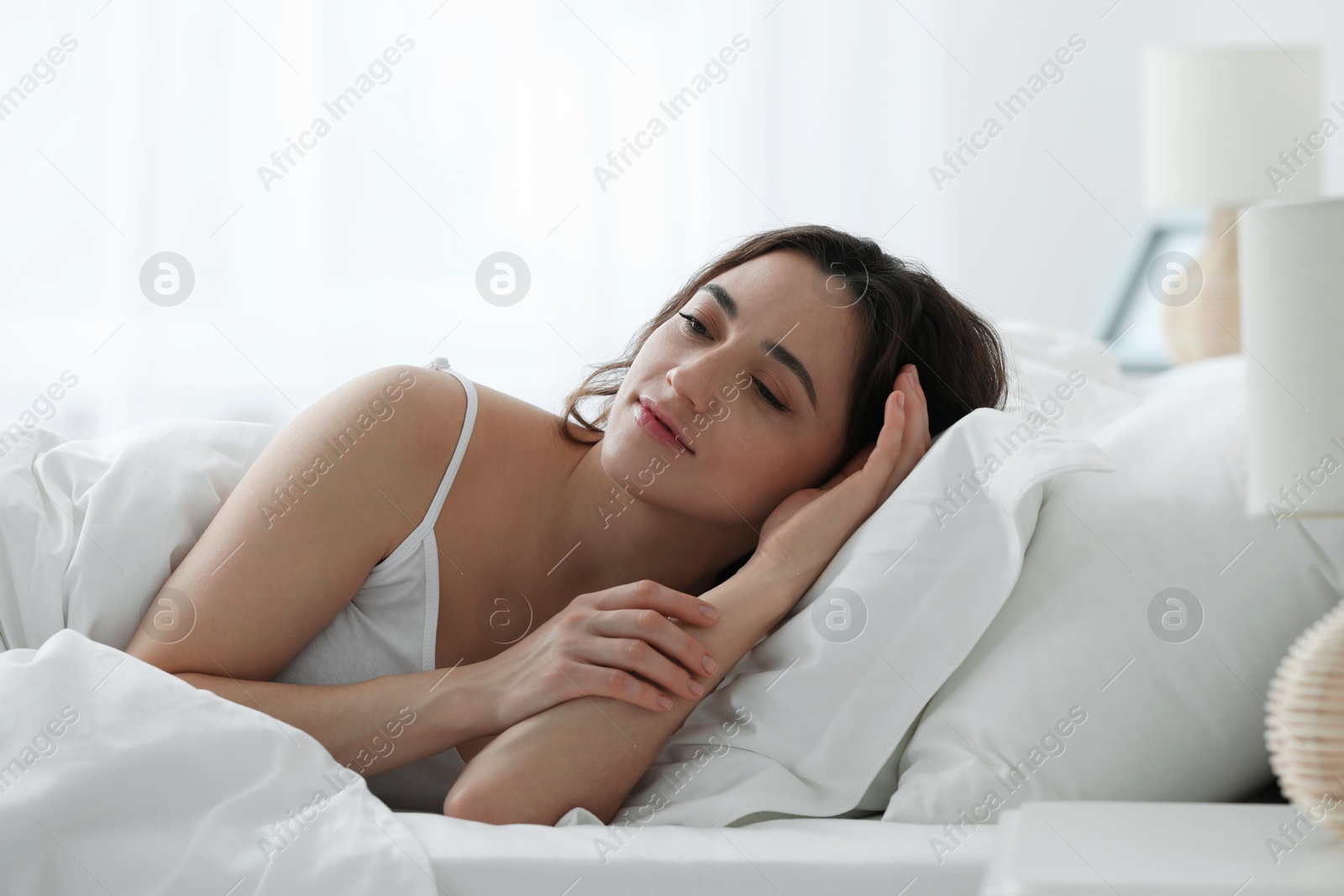 Photo of Bedtime. Beautiful woman lying in bed at home