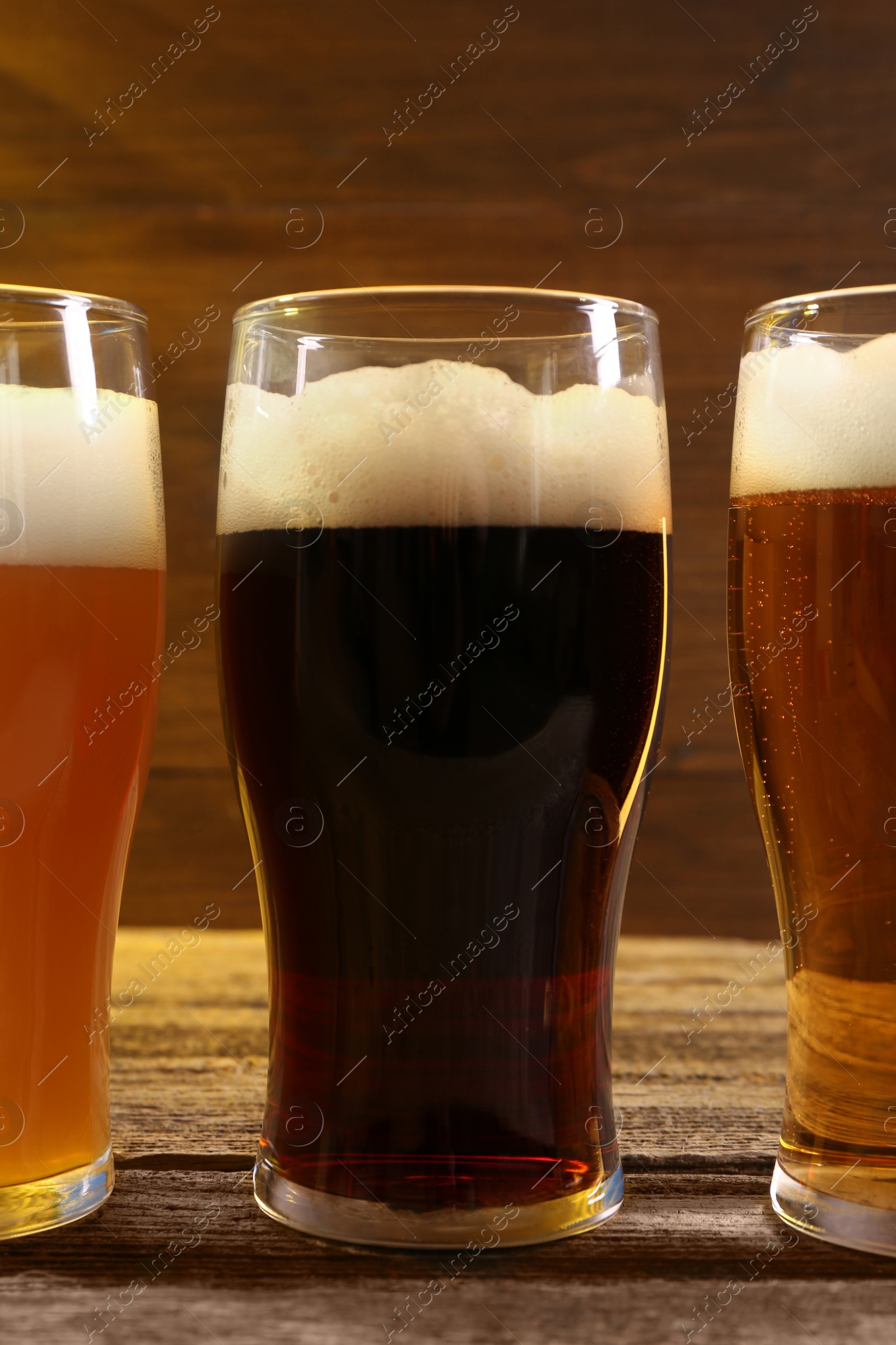 Photo of Glasses with different types of beer on wooden table