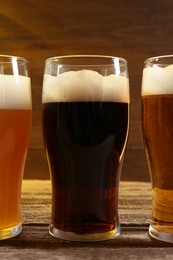 Glasses with different types of beer on wooden table