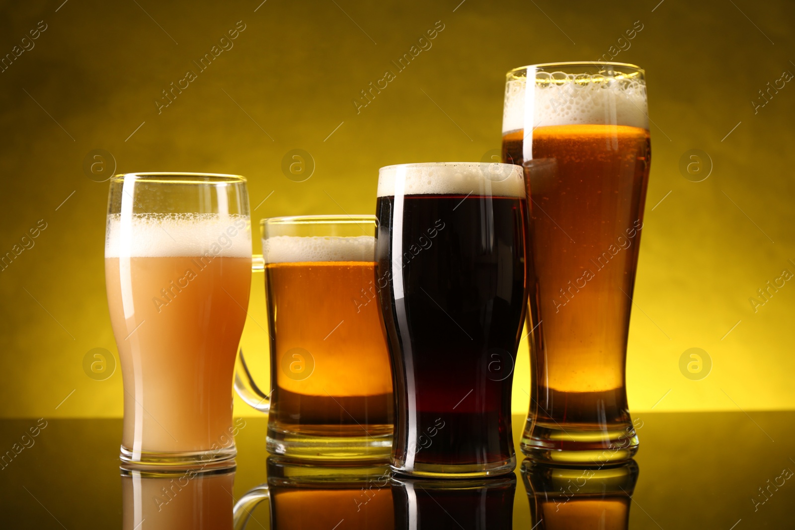 Photo of Glasses with different types of beer on dark table