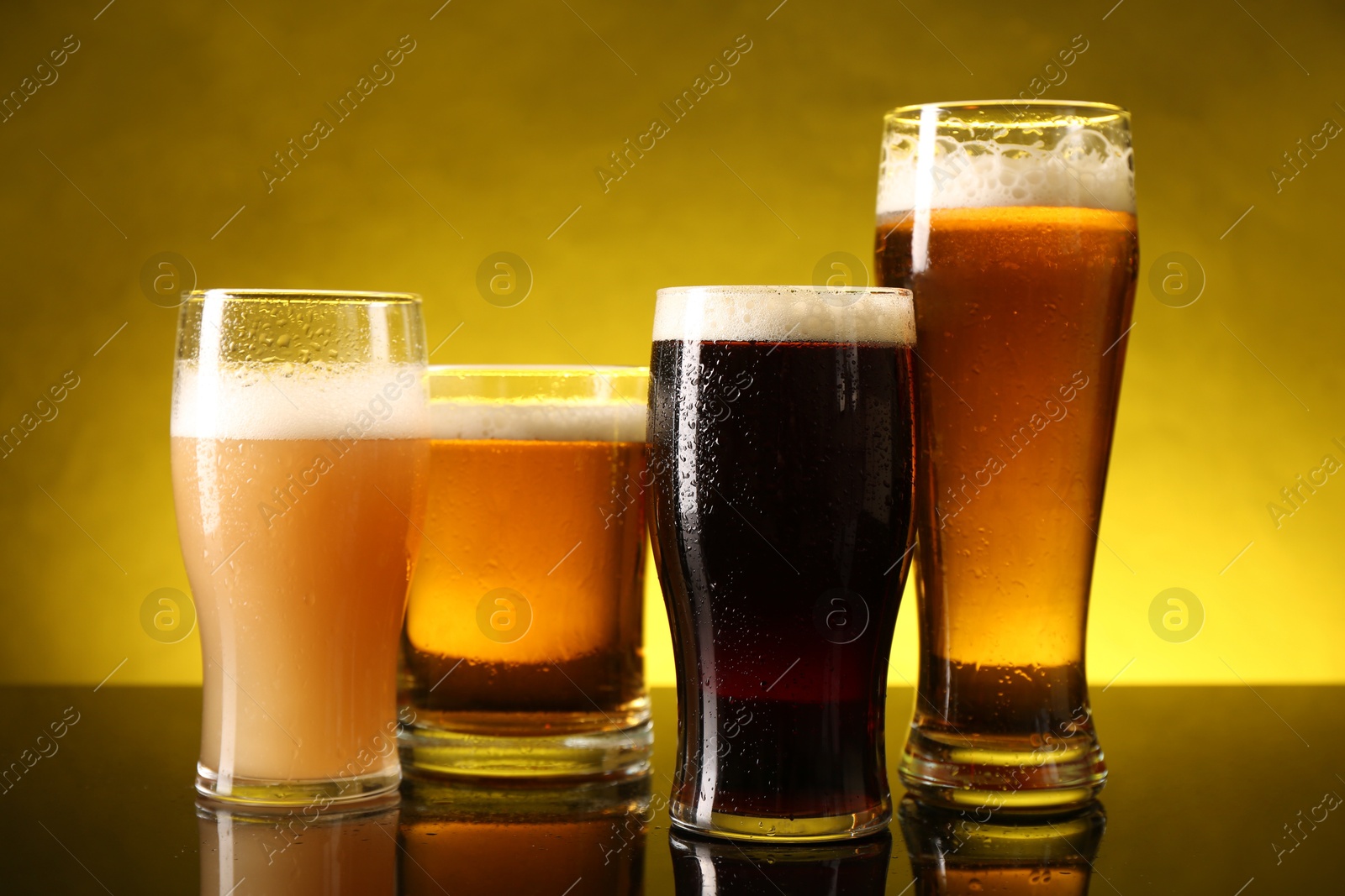 Photo of Glasses with different types of beer on dark table