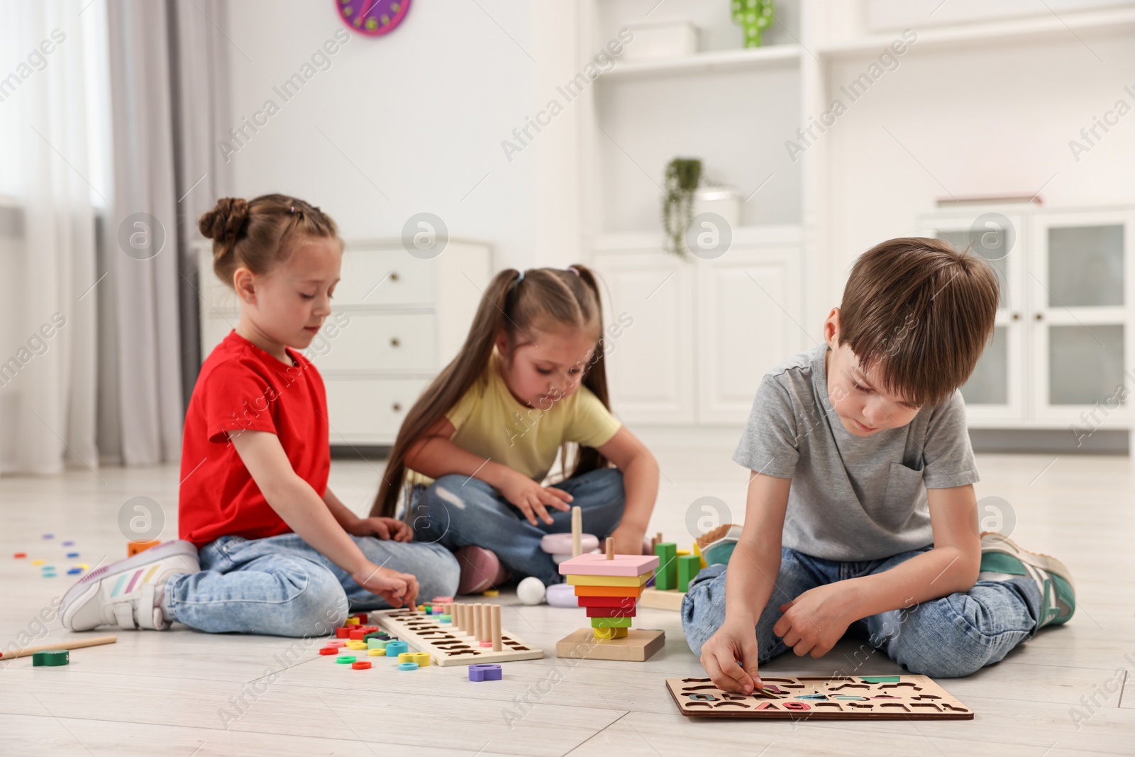 Photo of Cute little children playing together on floor indoors