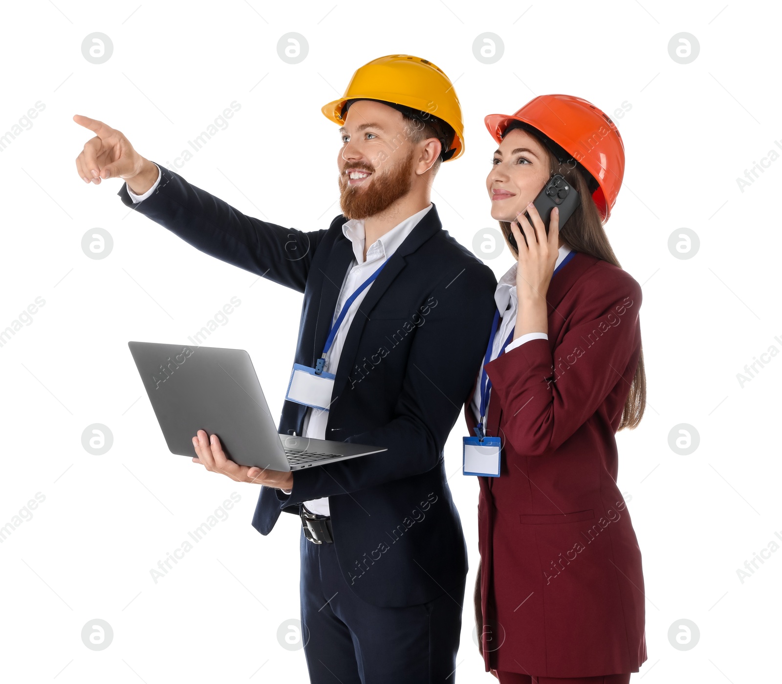 Photo of Engineer holding laptop while his colleague talking on smartphone against white background